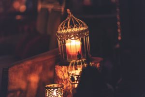 photo of brown metal cage with lighted candle