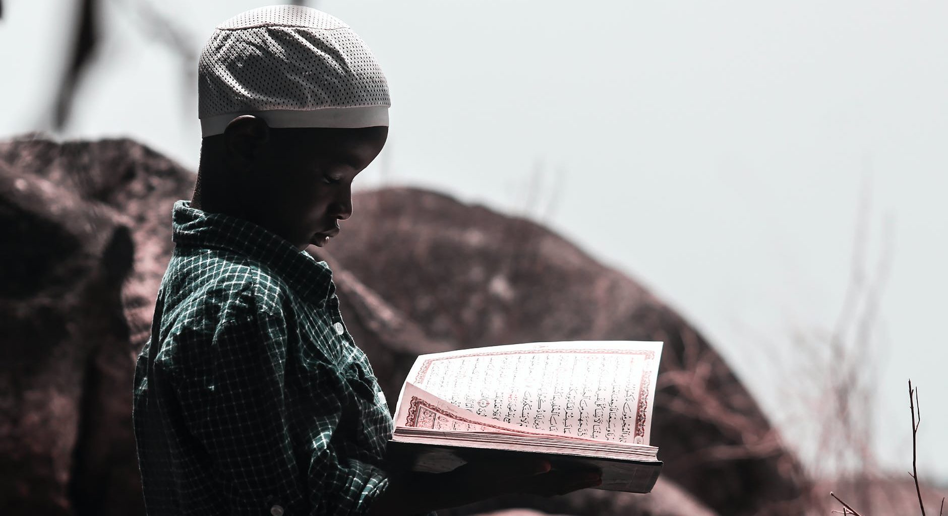 photo of boy holding religious book