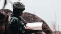 photo of boy holding religious book