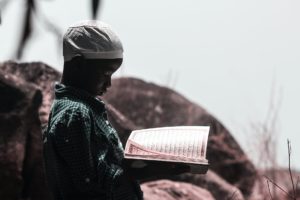 photo of boy holding religious book