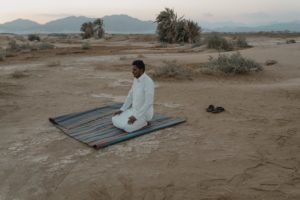 photo of man kneeling on mat