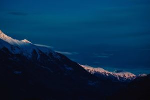 snowy mountainous valley under bright blue sky