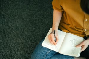 person writing on a notebook