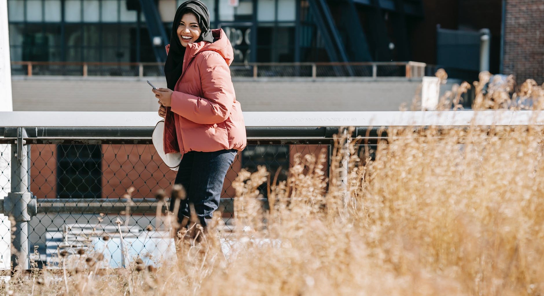 happy ethnic woman using smartphone on street