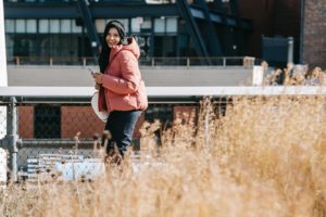 happy ethnic woman using smartphone on street